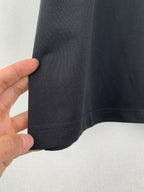 Side seam and sleeve edge close-up on a dark crew-neck T-shirt