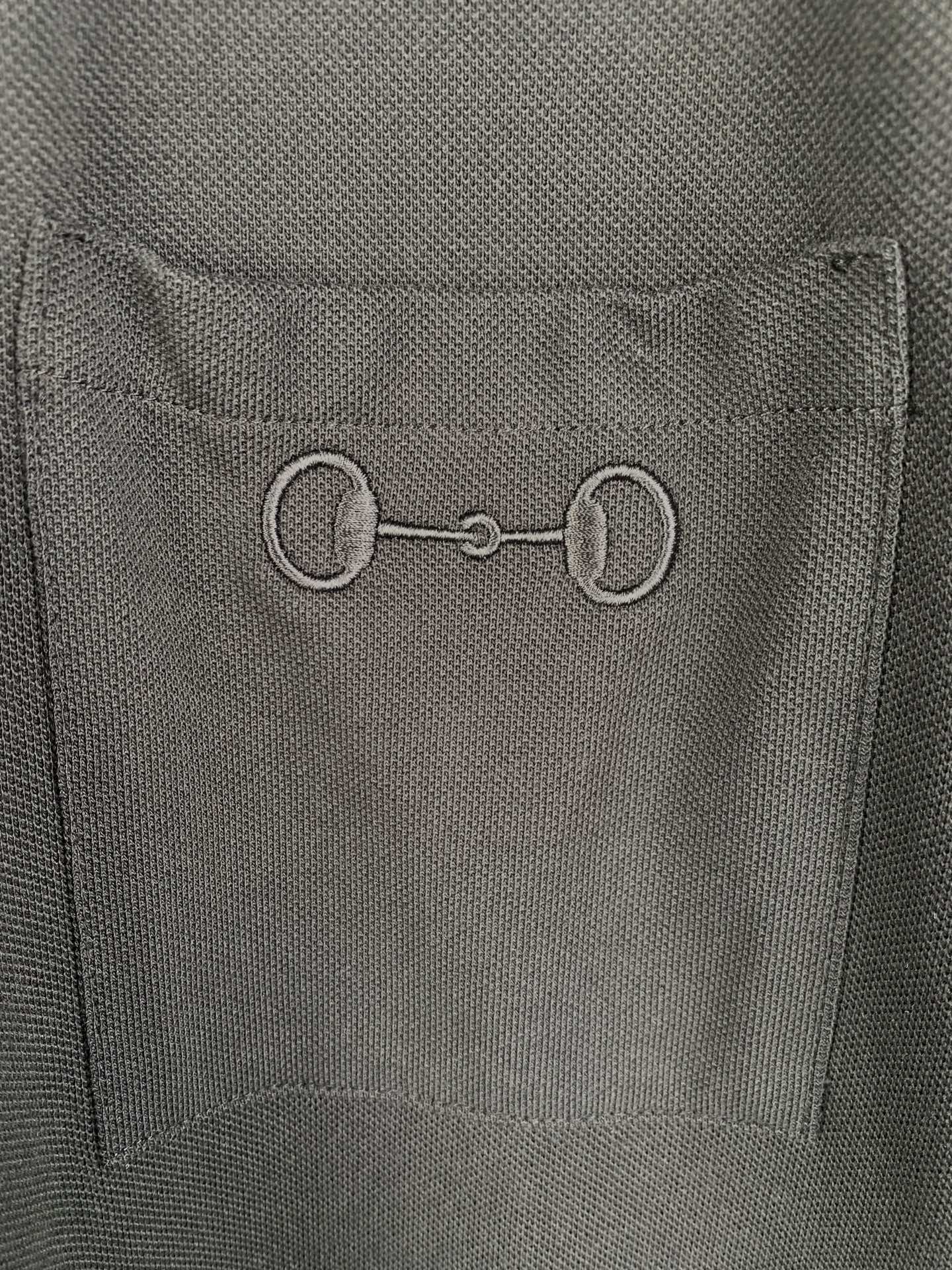 Close-up of Gucci inner neck label on a dark crew-neck T-shirt