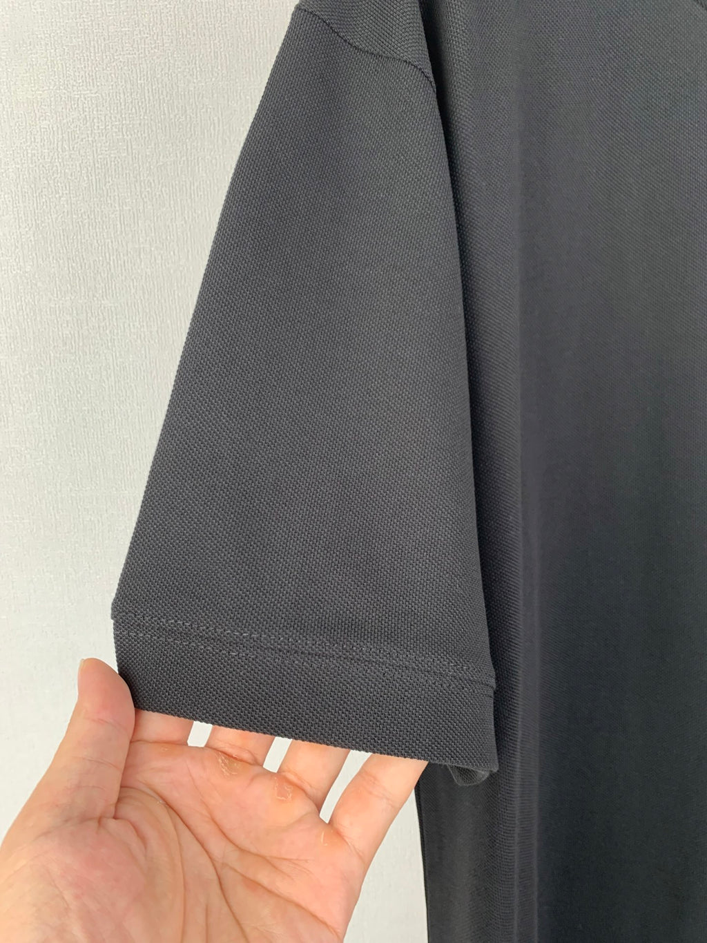 Sleeve hem close-up of dark crew-neck T-shirt with stitched cuff