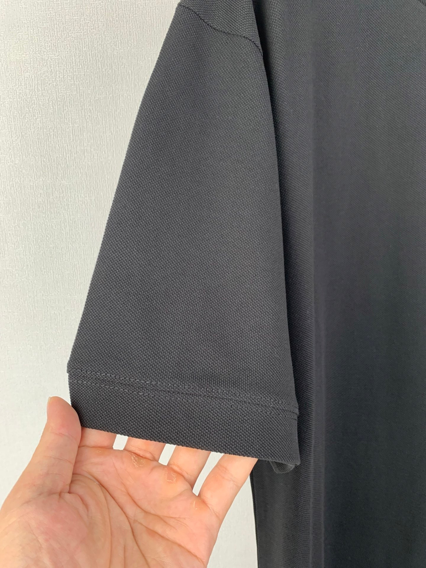 Sleeve hem close-up of dark crew-neck T-shirt with stitched cuff