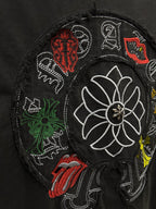 Black T-shirt embroidery close-up showing white flower and colorful stitched motifs.
