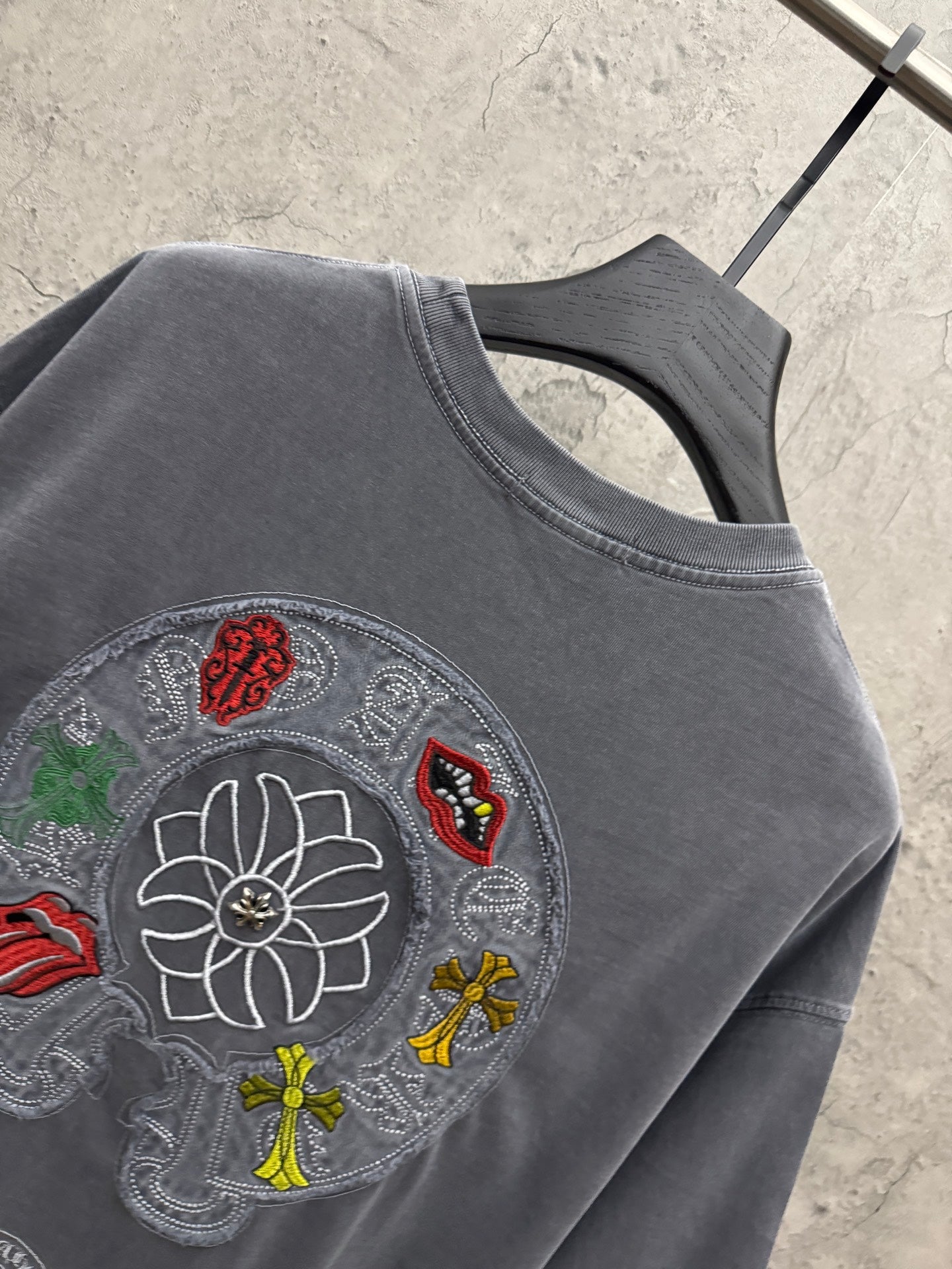Grey T-shirt close-up of large embroidered back graphic with floral motif