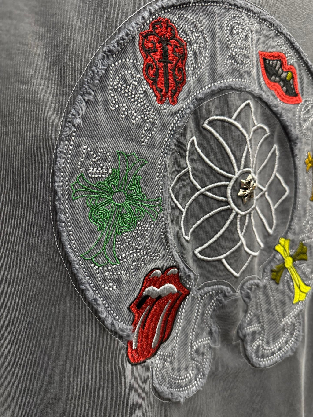 Grey T-shirt close-up of large embroidered back patch with floral and symbols