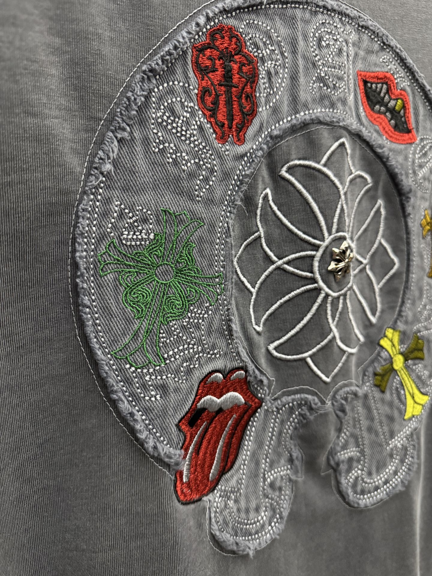 Grey T-shirt close-up of large embroidered back patch with floral and symbols