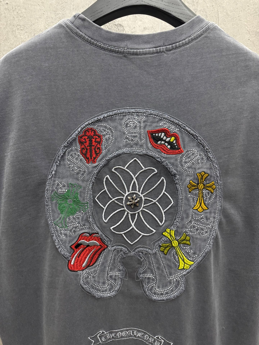 Grey T-shirt back with large circular embroidered floral graphic and figures
