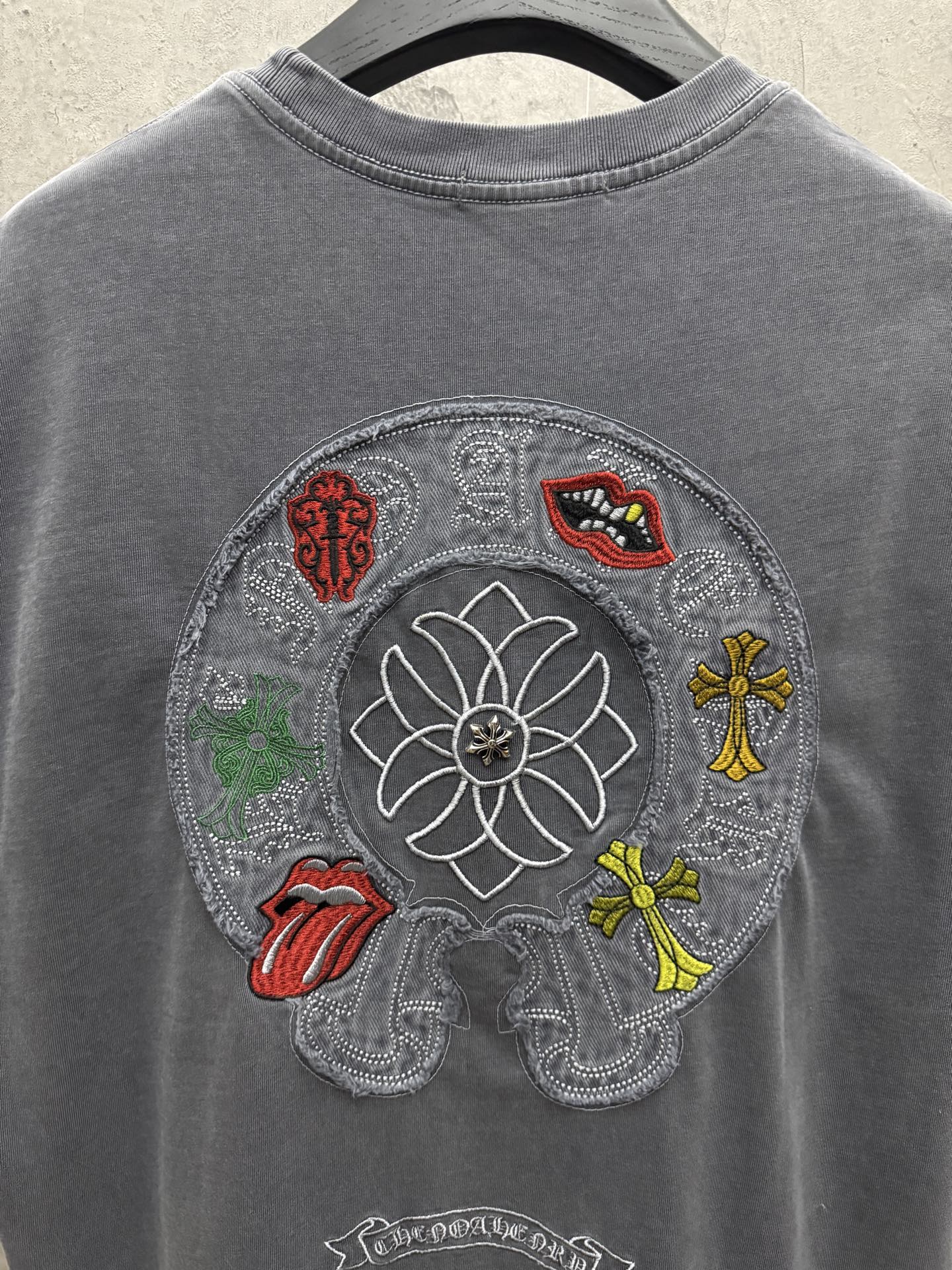 Grey T-shirt back with large circular embroidered floral graphic and figures
