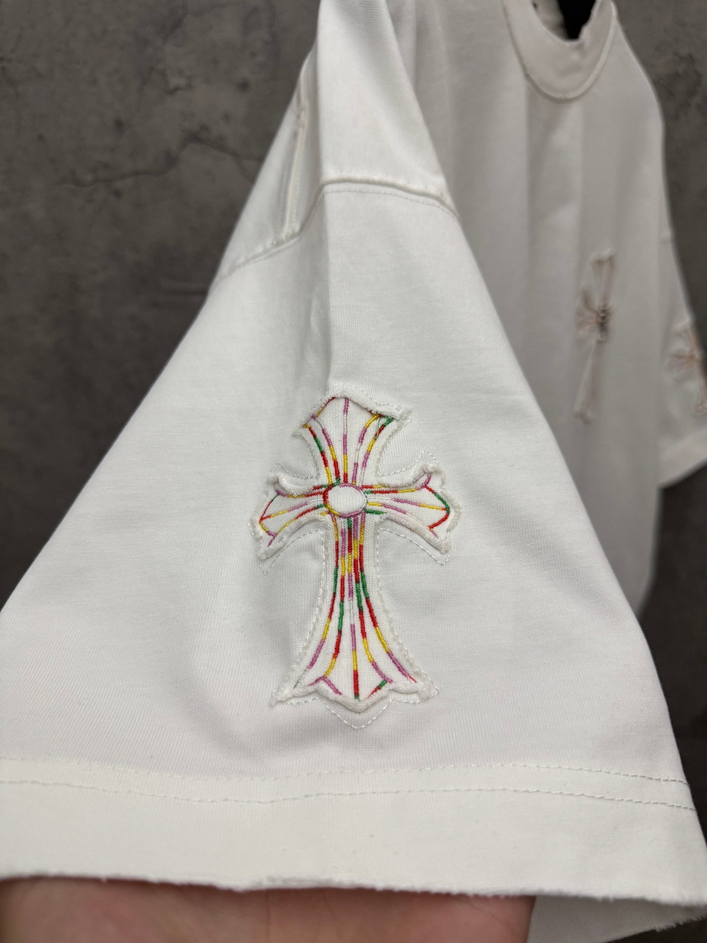 White short-sleeve T-shirt with embroidered cross at lower front hem