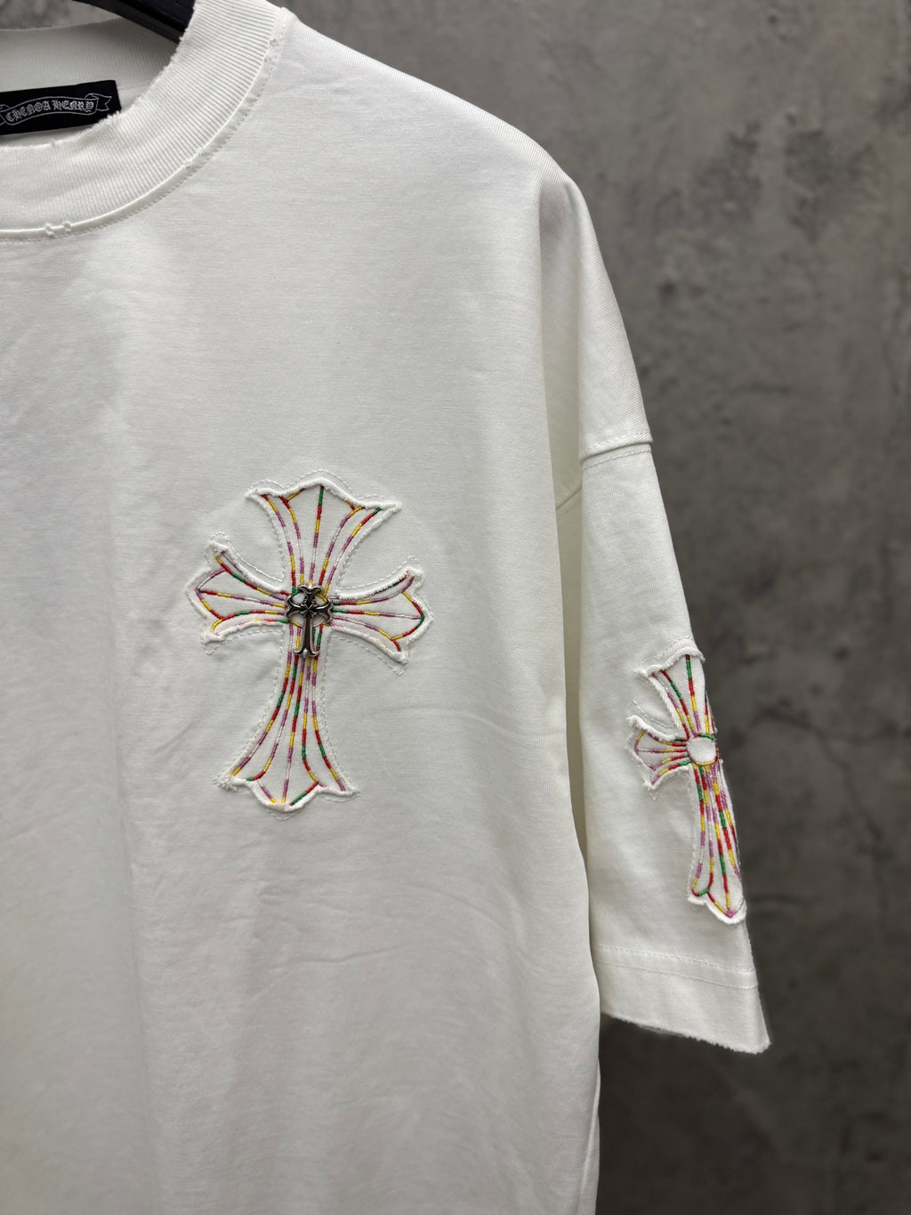 White short-sleeve T-shirt with cross embroidery on chest and matching sleeve motif