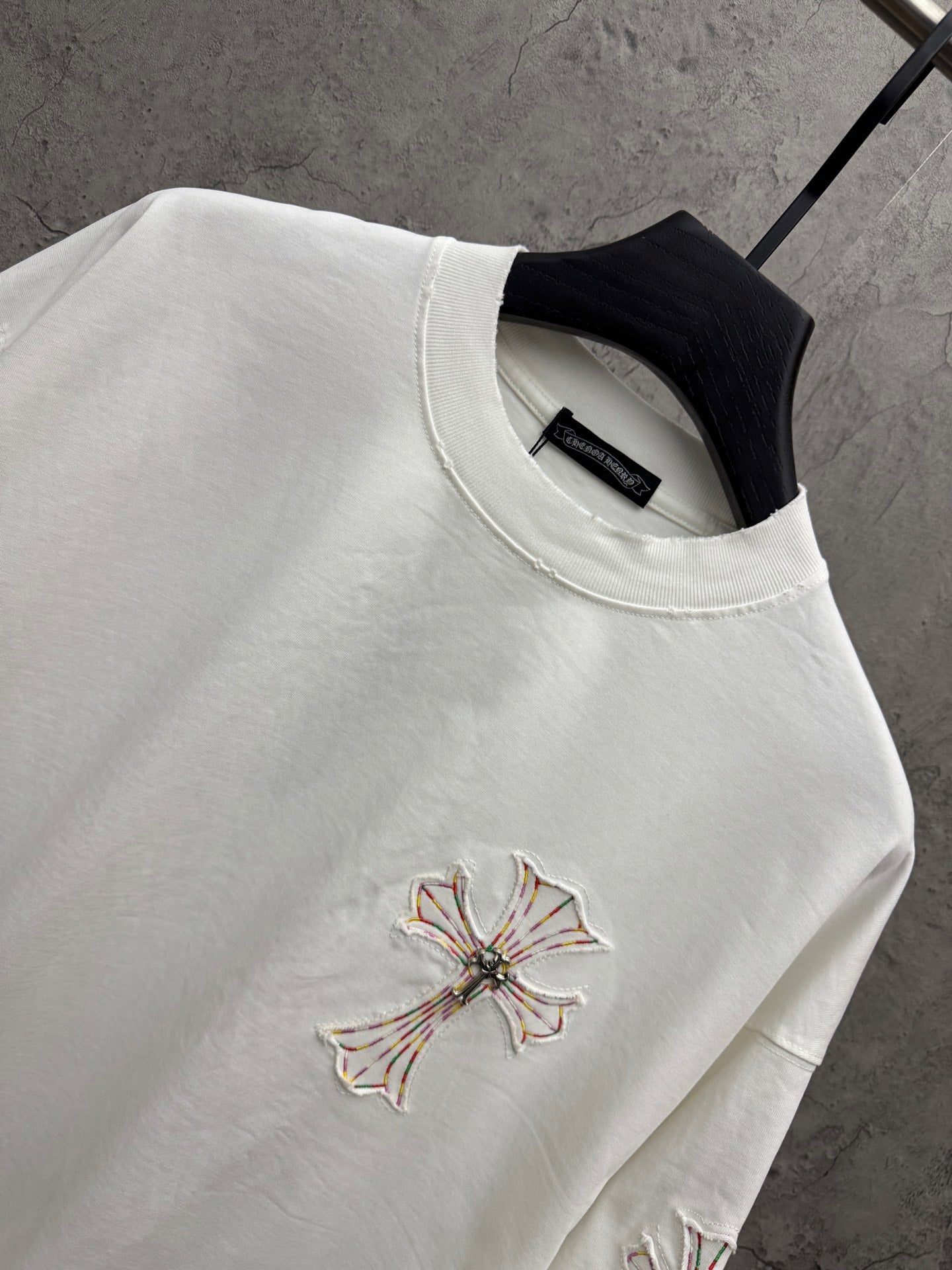 White short-sleeve T-shirt close-up of chest cross embroidery and crew neckline