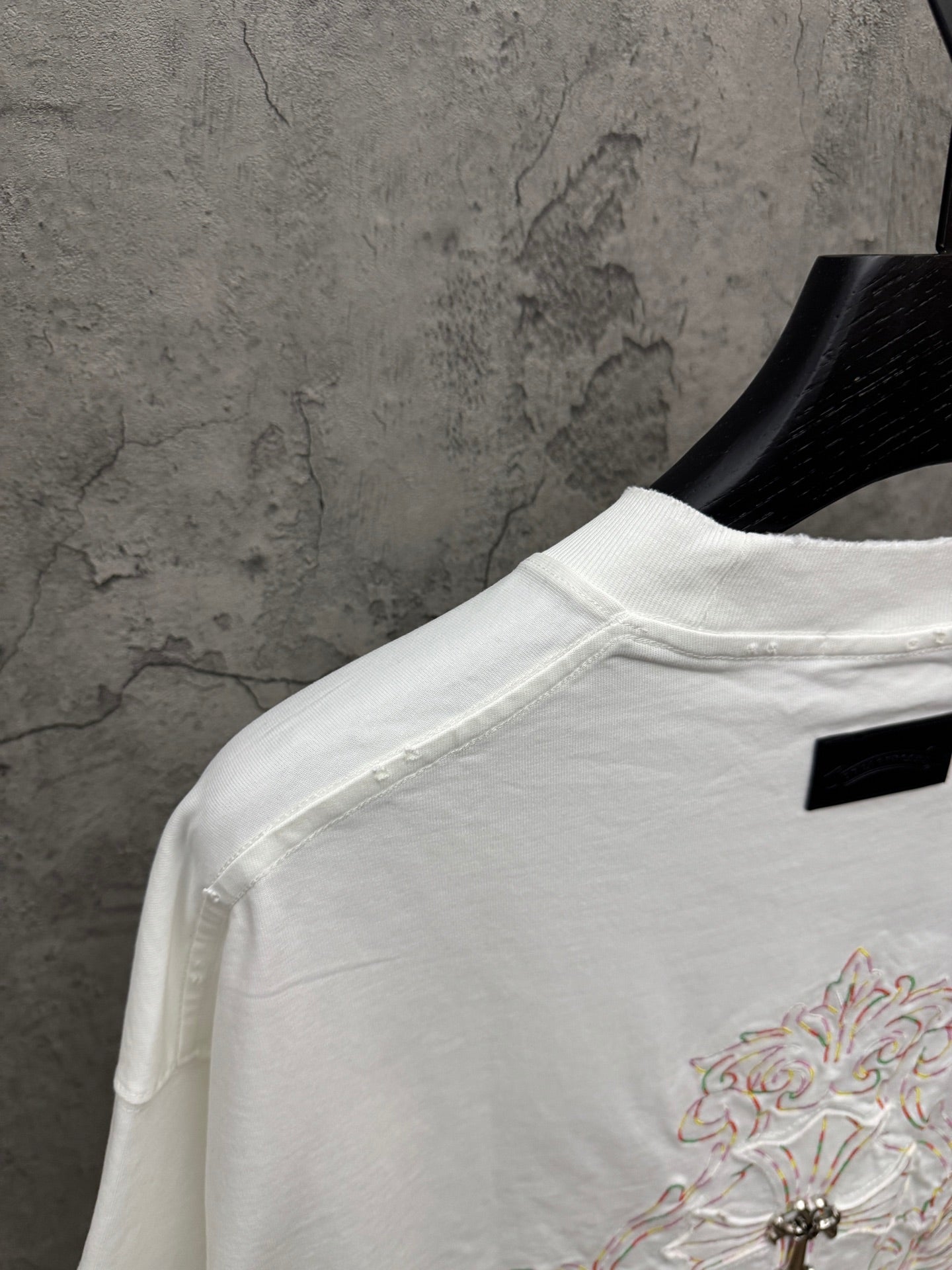 White short-sleeve T-shirt back view with small chest embroidery and black neck label