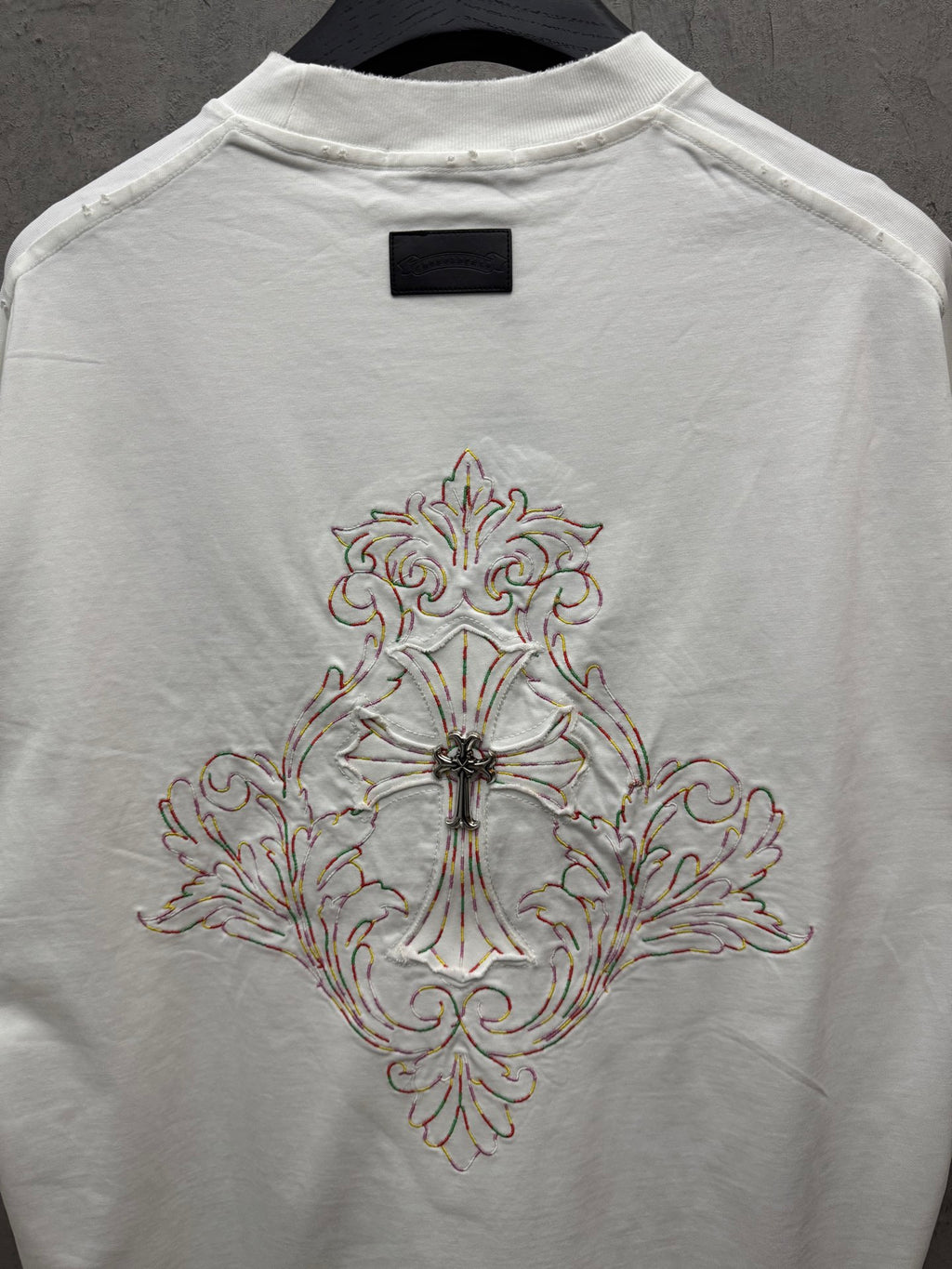 White short-sleeve T-shirt with large front cross embroidery on center back panel