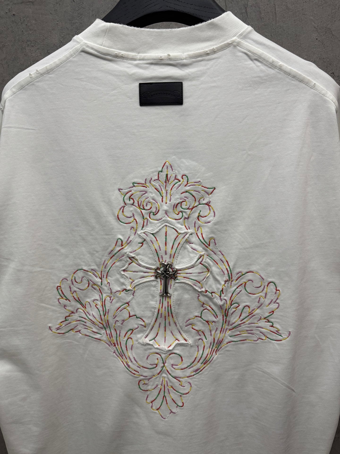 White short-sleeve T-shirt with large front cross embroidery on center back panel