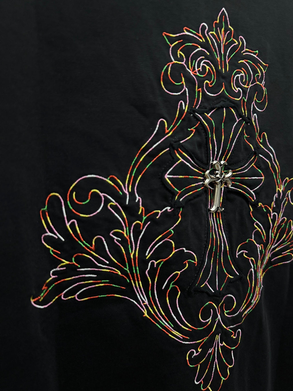 Black short-sleeve T-shirt close-up of colorful cross and floral embroidery
