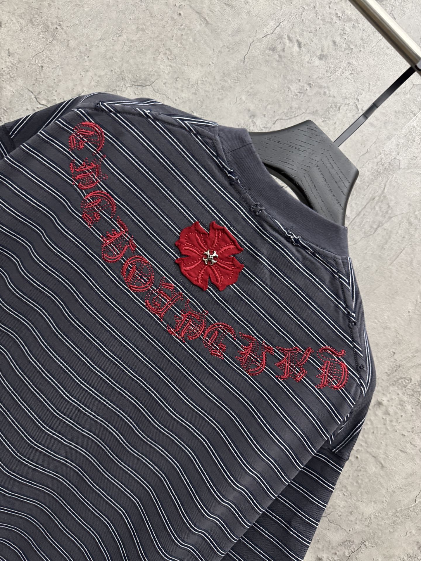 Navy striped short-sleeve shirt with red flower and script embroidery across chest