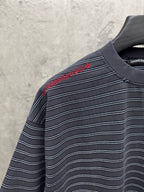 Navy striped short-sleeve shirt with red embroidered script near shoulder