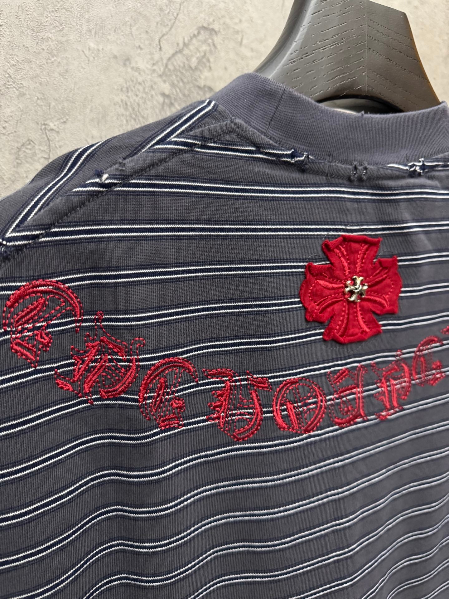 Navy striped short-sleeve shirt with red flower appliqué and script embroidery