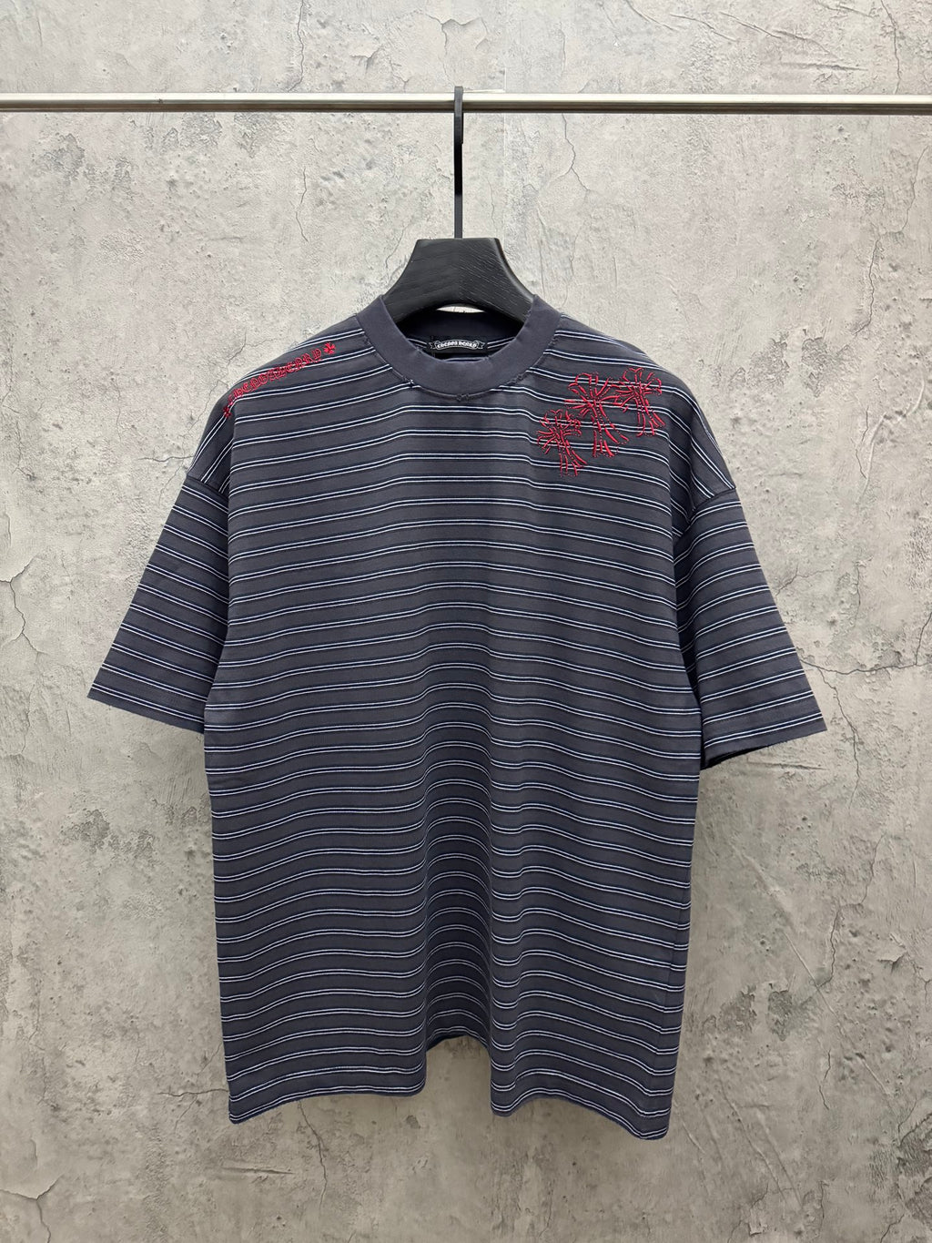 Navy short-sleeve striped crewneck shirt with red embroidered design at chest