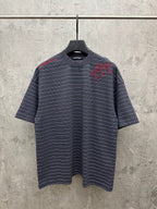 Navy short-sleeve striped crewneck shirt with red embroidered design at chest