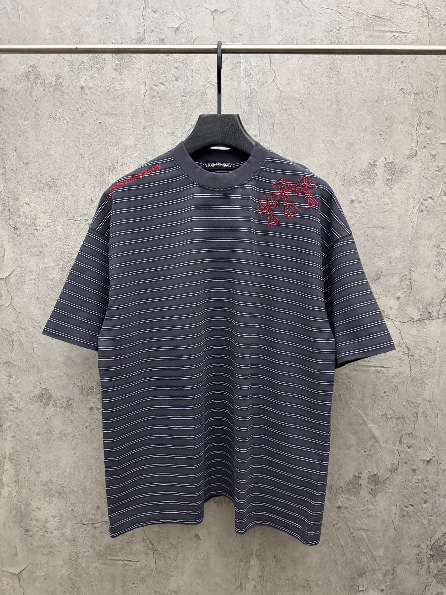 Navy short-sleeve striped crewneck shirt with red embroidered design at chest