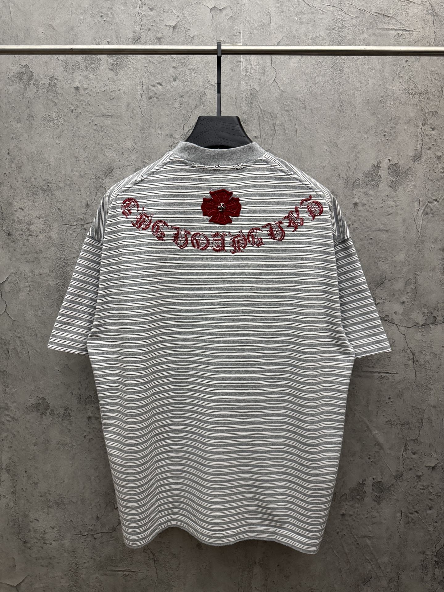 Striped short-sleeve T-shirt with red embroidered script across upper back, crew neck.