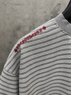 Striped short-sleeve T-shirt with red embroidered script on side shoulder near hem.