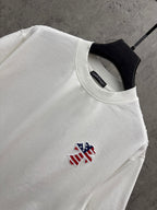 White T-shirt close-up: crew neck and small embroidered patriotic figure