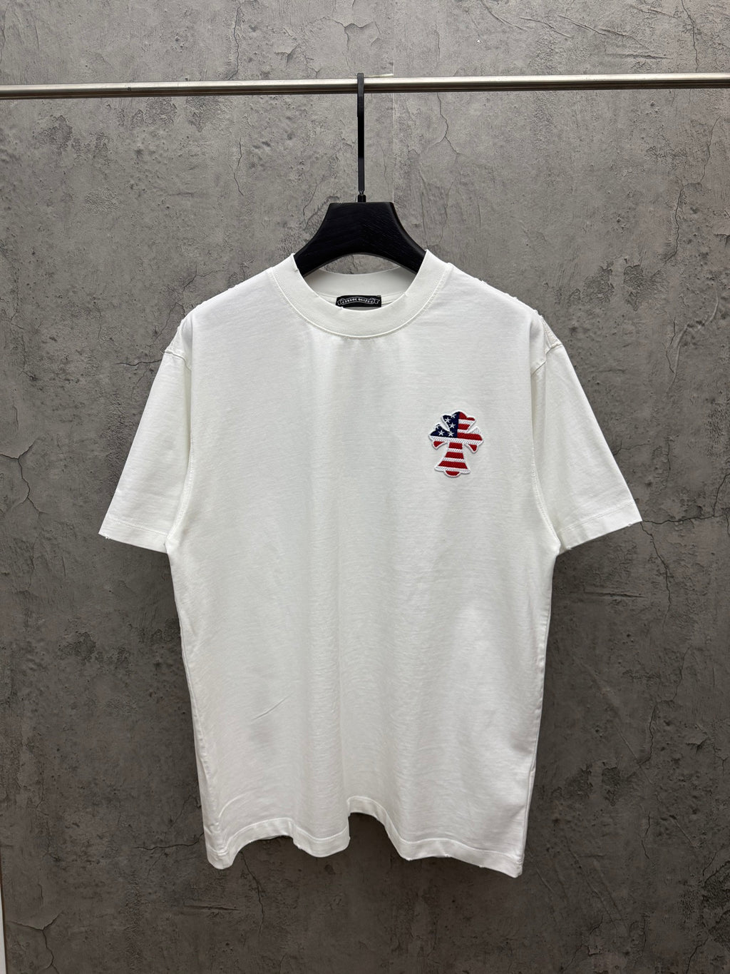 White short-sleeve T-shirt with small embroidered patriotic figure on left chest