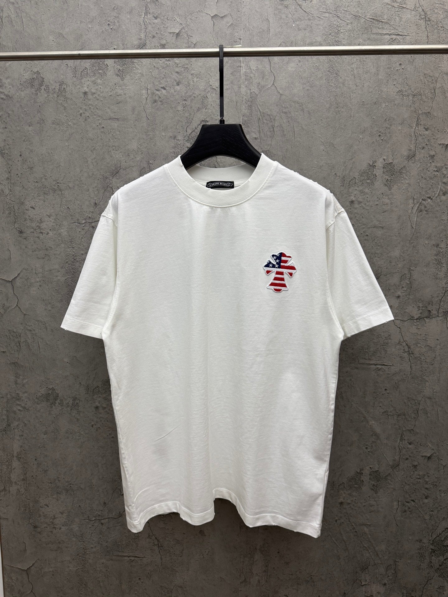 White short-sleeve T-shirt with small embroidered patriotic figure on left chest