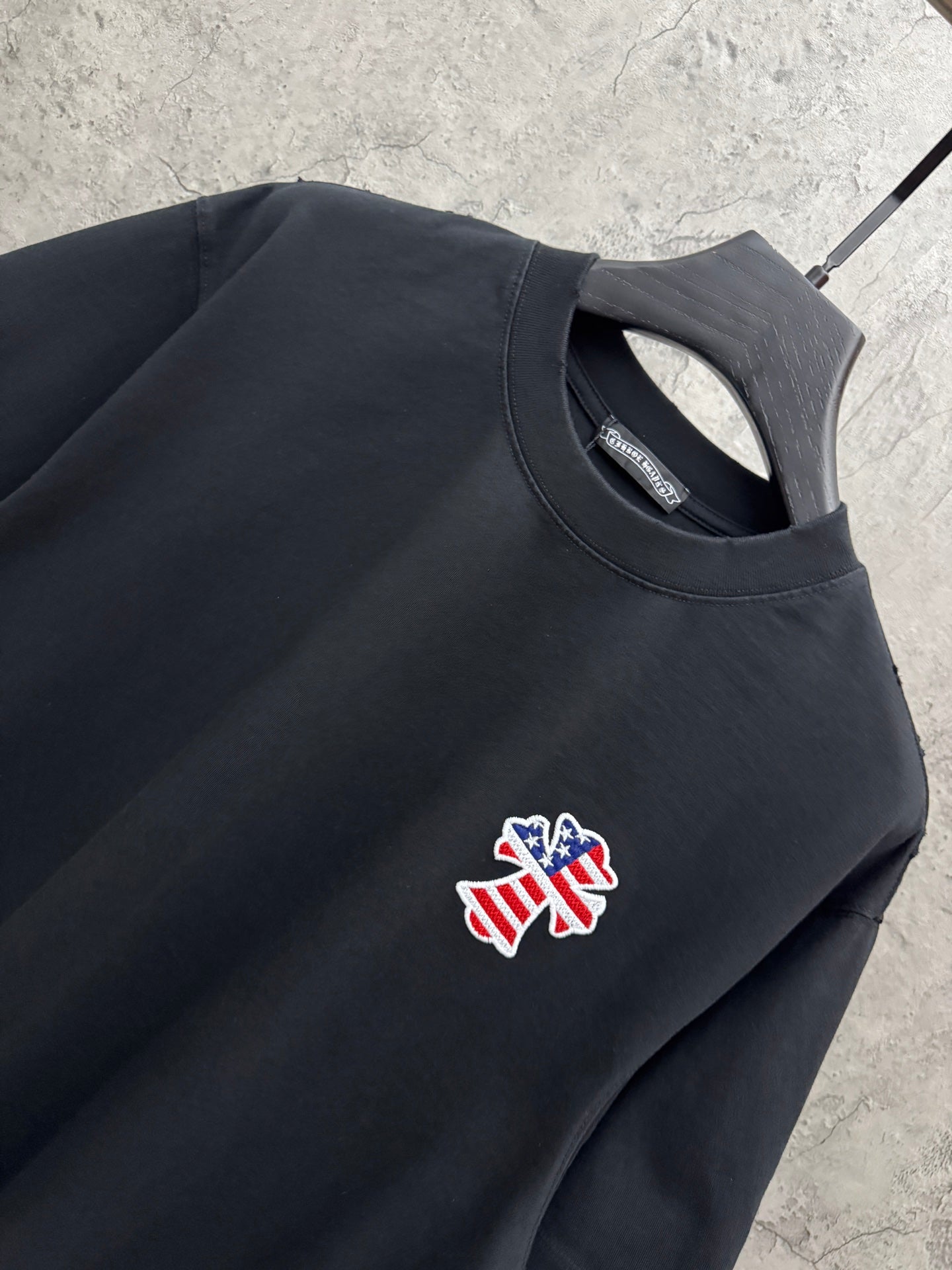 Close-up of black short-sleeve T-shirt chest graphic and crew neckline