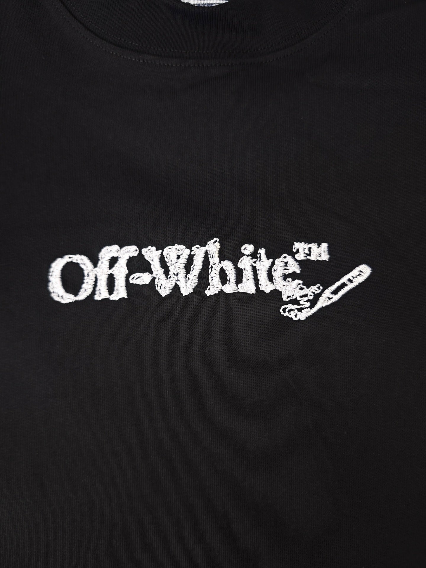 Black T-shirt close-up of white Off-White logo graphic on the chest