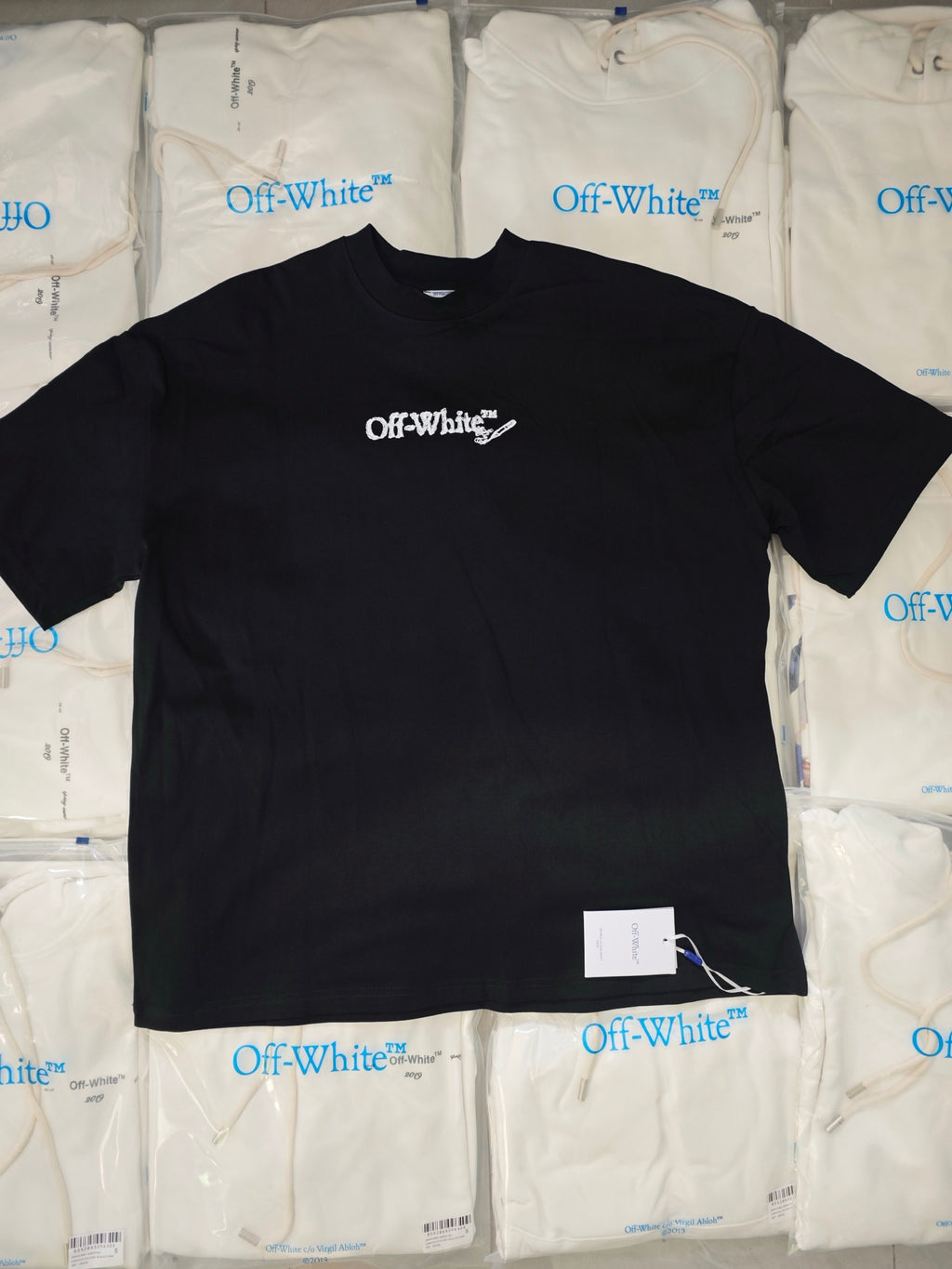 Black crewneck T-shirt with small Off-White logo on chest and white size tag