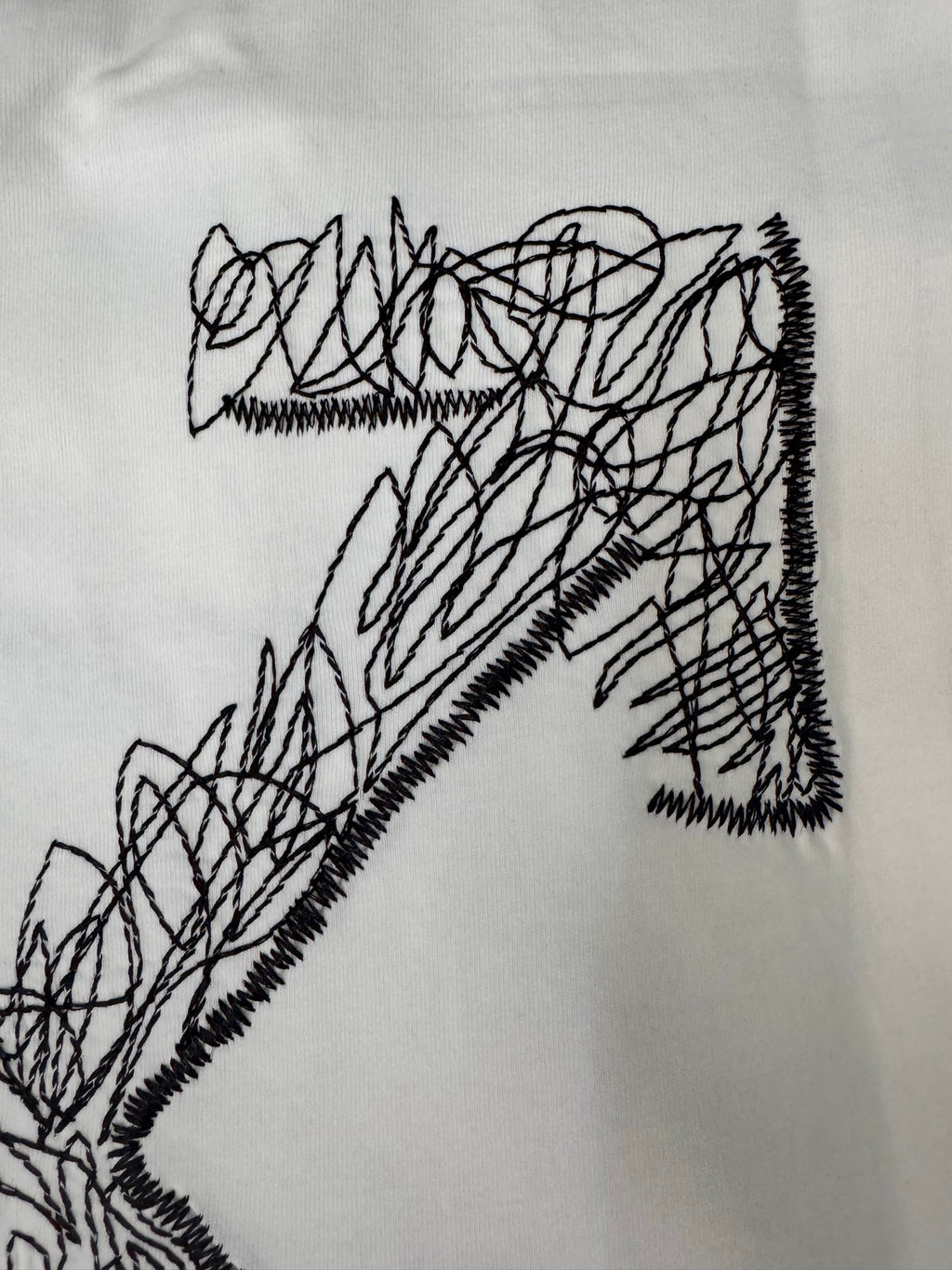 Off-White T-shirt front graphic close-up: black X-style scribble design