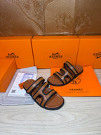 Hermes slide sandals with dark blue straps and tan footbeds, front-angled view