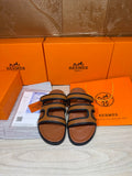 Hermes slide sandals with dark blue straps and tan leather footbeds, pair view