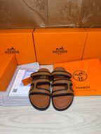 Hermes slide sandals with dark blue straps and tan leather footbeds, pair view