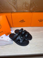 Hermes sandals in dark leather, two wide straps across the foot with open-toe style