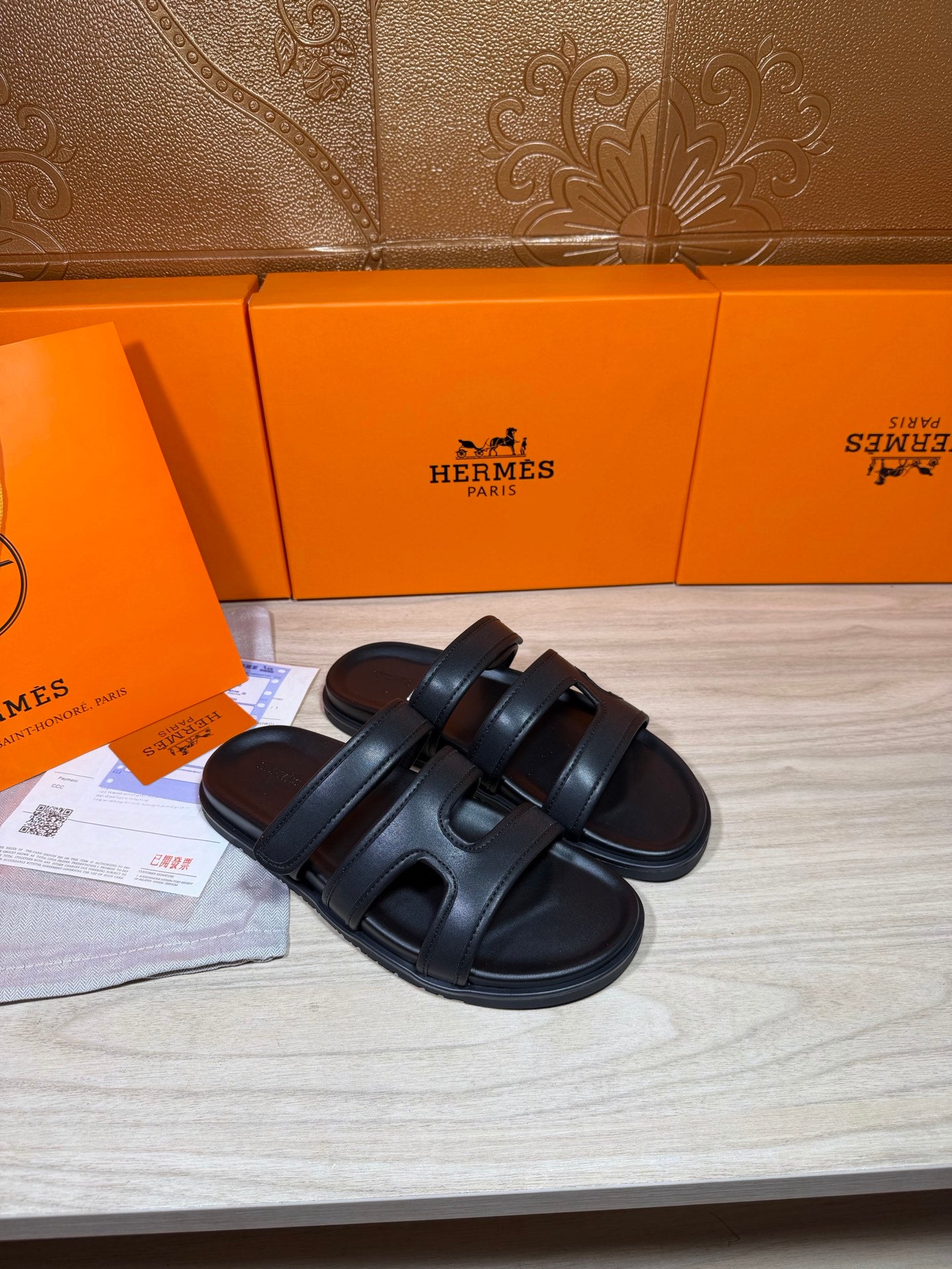 Hermes sandals in dark leather, two wide straps across the foot with open-toe style