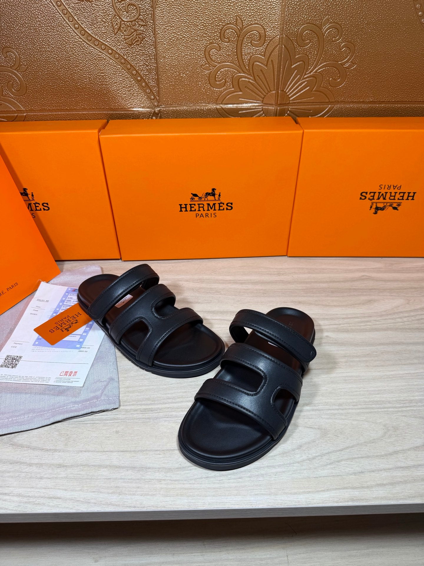 Hermes sandals in dark leather with double straps and open toe, shown side by side