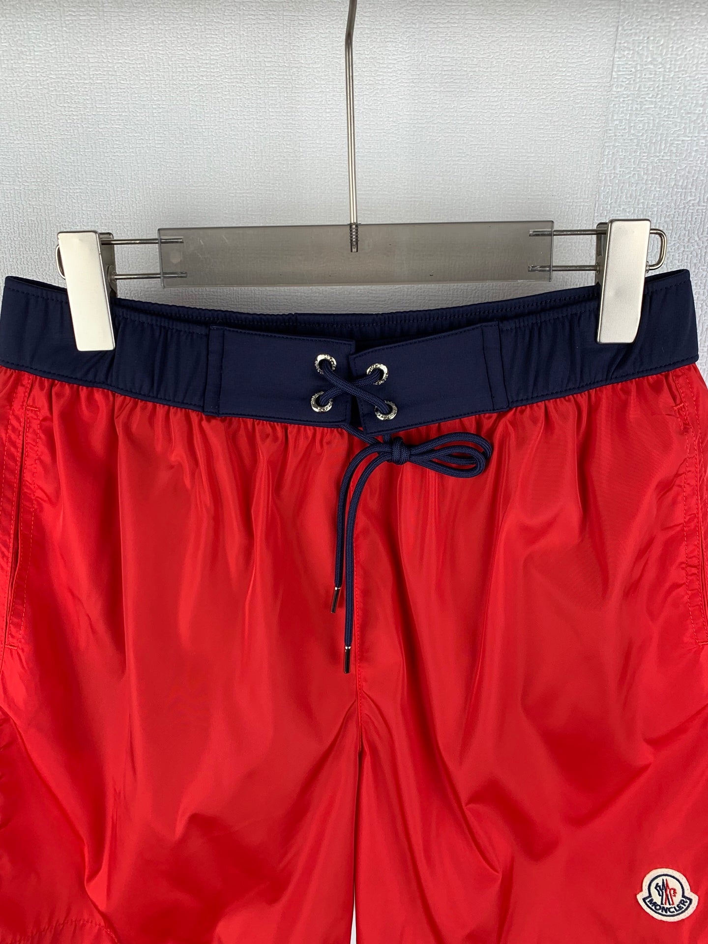 Moncler red shorts with navy elastic waistband and lace-up drawstring, logo on leg