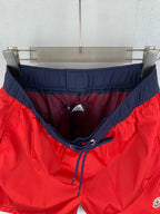 Red and navy pants with elastic waistband and drawstring at center front