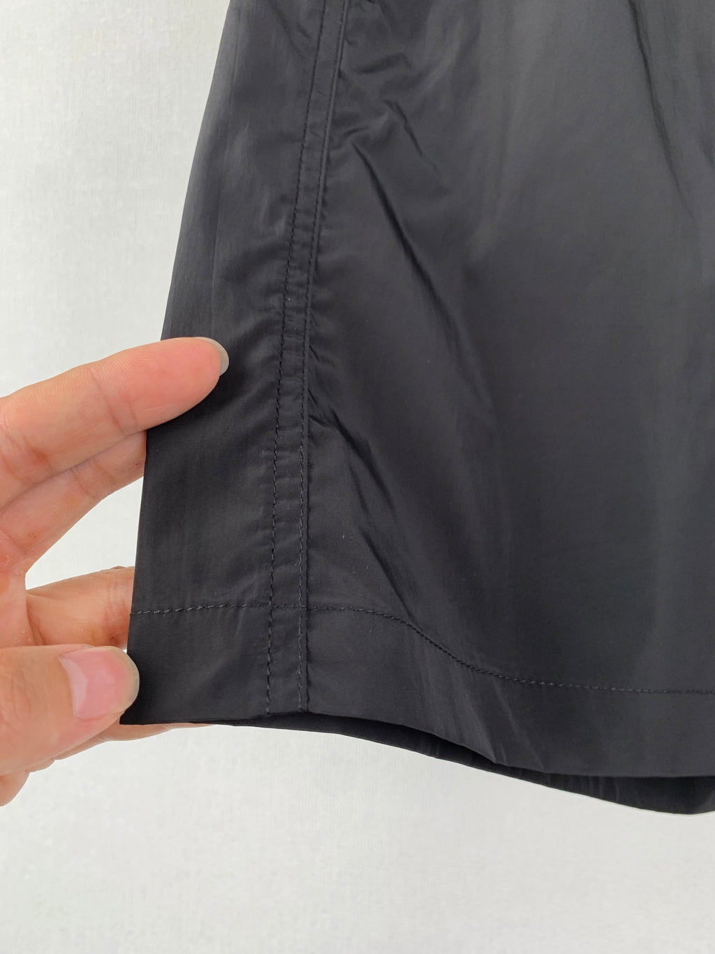 Moncler black swim shorts fabric close-up with stitched vertical seam