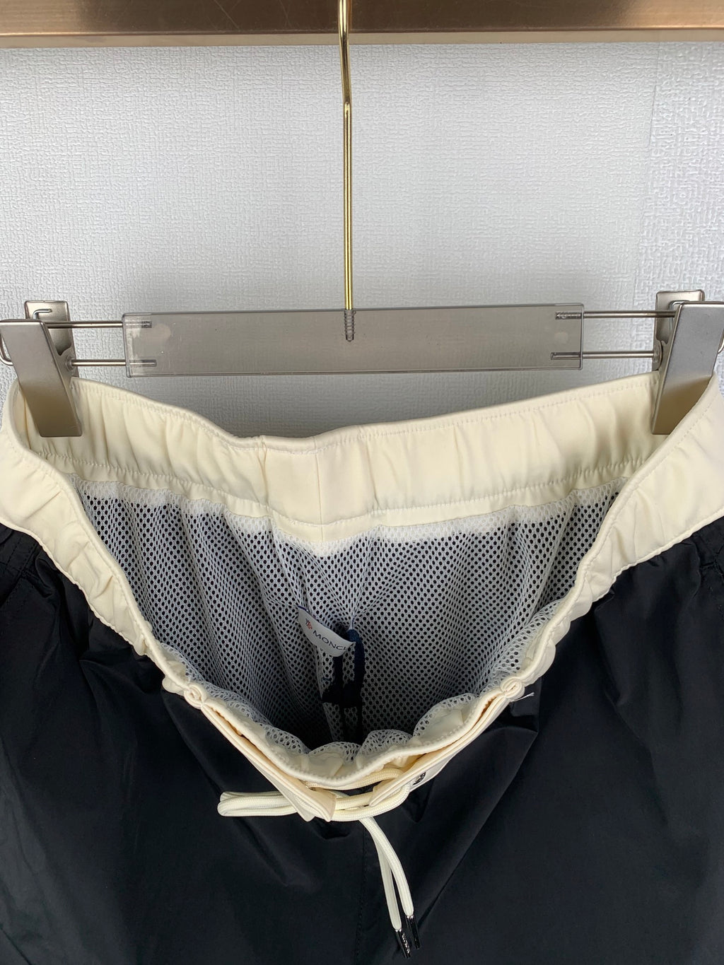 Black pants with cream waistband and drawstring, mesh side panel detail