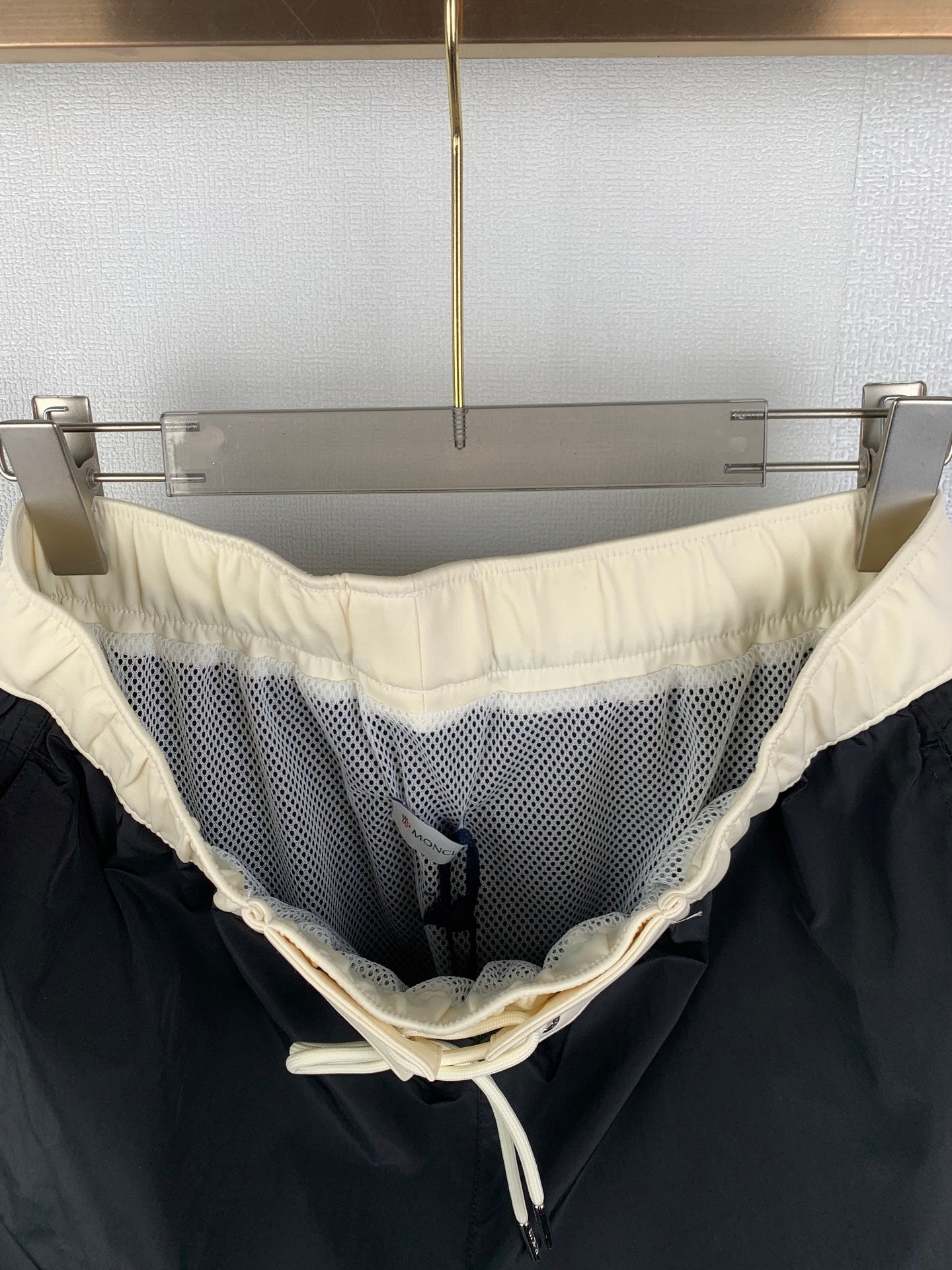 Black pants with cream waistband and drawstring, mesh side panel detail