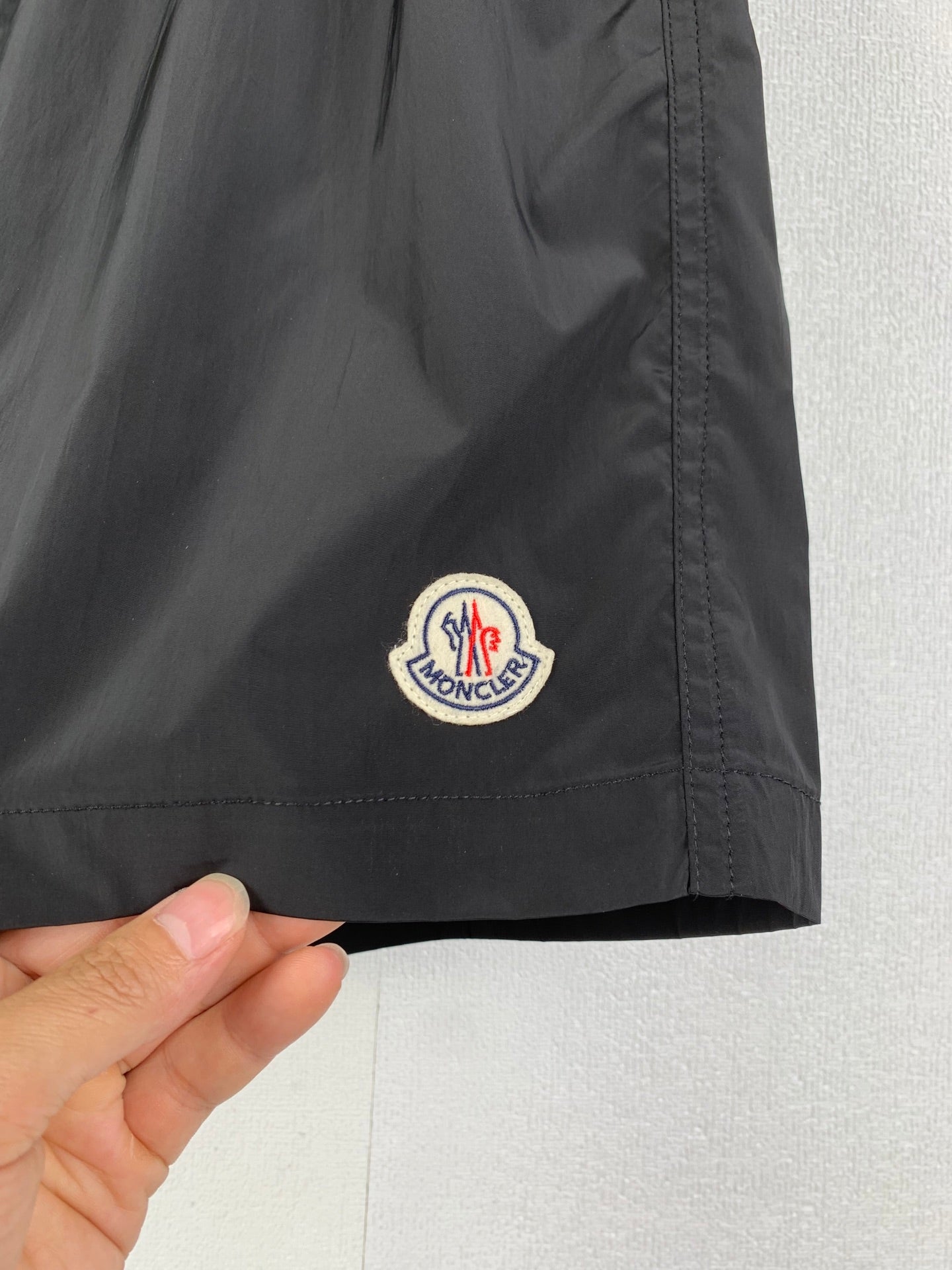 Moncler black swim shorts hem with embroidered Moncler logo patch