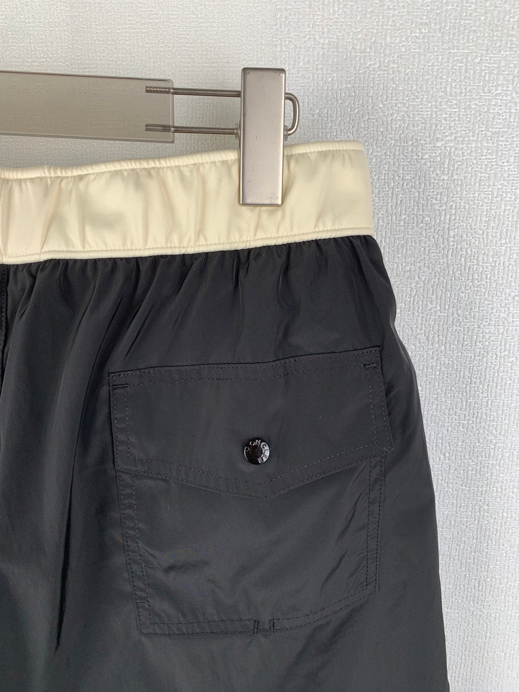 Moncler black swim shorts close-up of cream waistband and side pocket patch