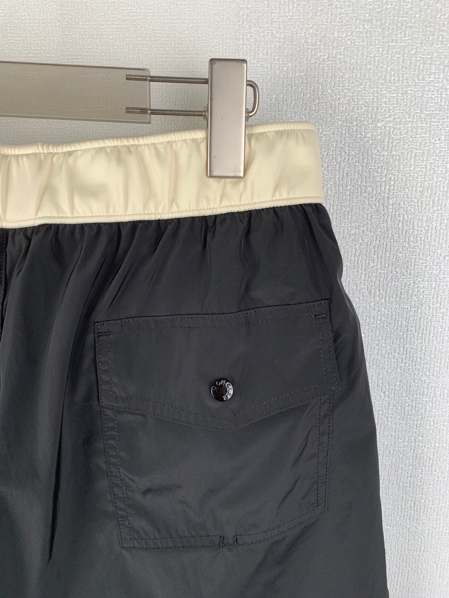 Moncler black swim shorts close-up of cream waistband and side pocket patch