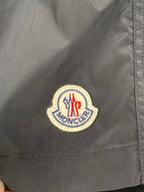 Moncler logo patch on black swim shorts fabric close-up