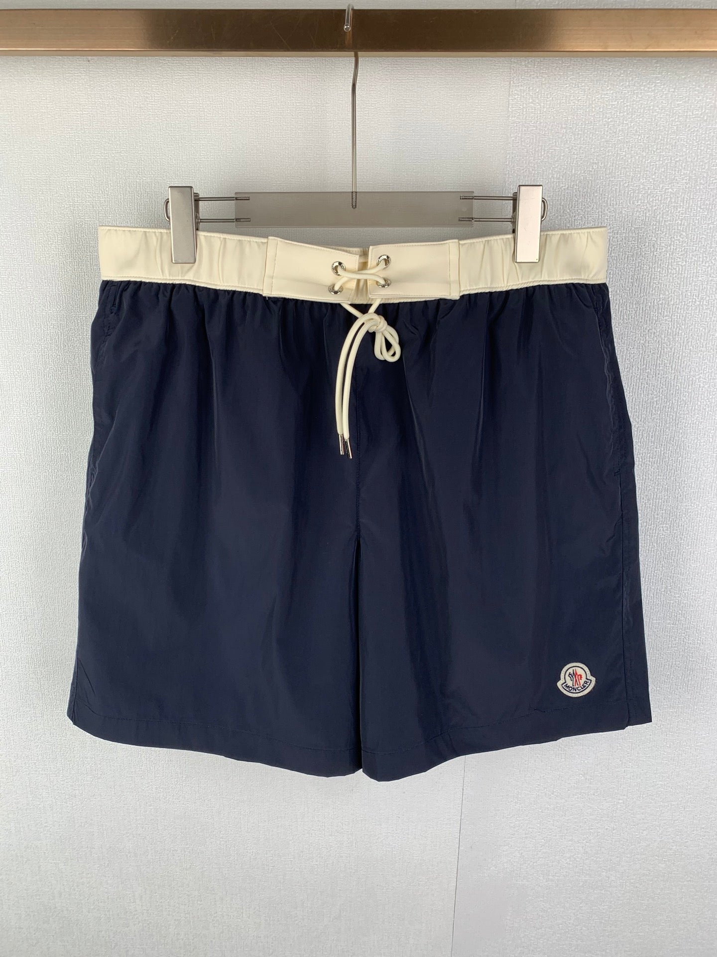 Moncler navy shorts-style pants with white drawstring waist and side pocket
