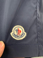 Moncler navy pants close-up of round embroidered logo patch