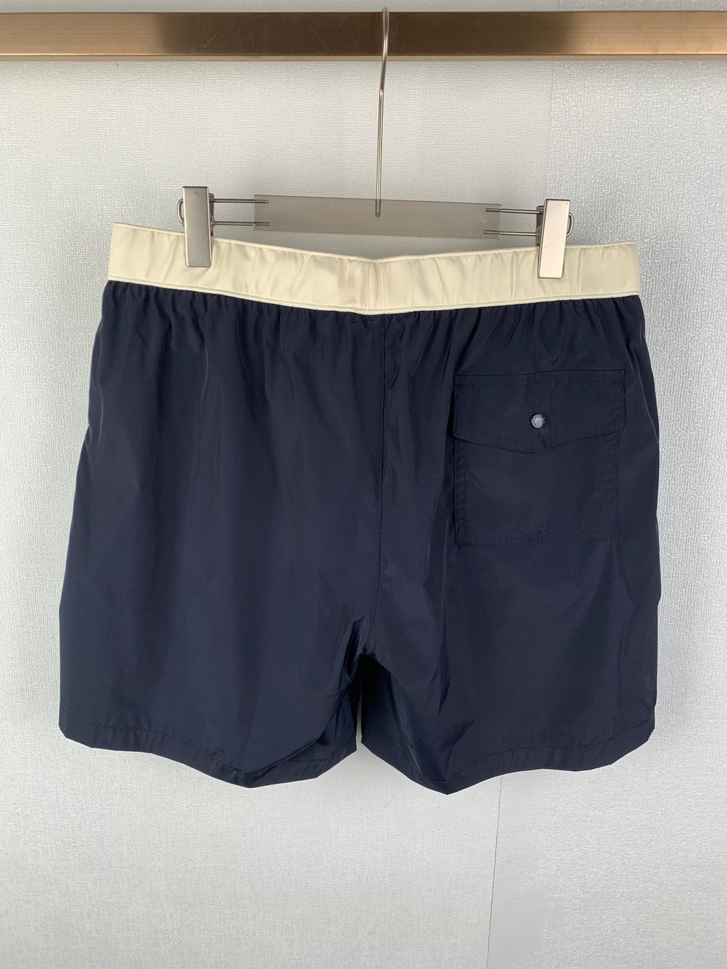 Moncler navy shorts-style pants with straight legs and single visible side pocket